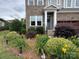 Close-up of a brick home with a welcoming front door and colorful flower beds at 1124 Greenbridge Dr, Matthews, NC 28105