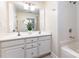 Clean bathroom featuring double sinks, white cabinets and shower-tub combo at 1136 W 1St St, Charlotte, NC 28202