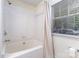 Clean bathroom featuring shower-tub combo and window with blinds at 1136 W 1St St, Charlotte, NC 28202