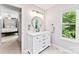 This bright bathroom includes a new vanity, modern fixtures, and a view to the tree-lined yard at 116 Oak Creek Dr, Charlotte, NC 28270