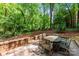Cozy stone patio with a dining table and lush greenery in the background at 116 Oak Creek Dr, Charlotte, NC 28270