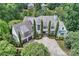 An aerial view of a grand home featuring a slate roof, lush landscaping, three car garage and paver driveway at 11710 Ney Manor Way, Charlotte, NC 28277