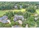 An aerial view of an estate home with a circular driveway, manicured landscaping and many trees at 11710 Ney Manor Way, Charlotte, NC 28277