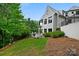 A charming backyard featuring lush grass, landscaping, and a modern-style home with black trim at 11710 Ney Manor Way, Charlotte, NC 28277