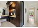 Bathroom features a dark wood vanity with marble countertop, storage cabinets, decorative mirror, and tile floor at 11710 Ney Manor Way, Charlotte, NC 28277