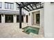An outdoor courtyard featuring a small spa and dark wood pergola in a luxury backyard at 11710 Ney Manor Way, Charlotte, NC 28277