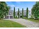 Beautiful home featuring manicured landscaping, mature trees, paver driveway, and a three car garage at 11710 Ney Manor Way, Charlotte, NC 28277