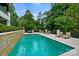 A swimming pool with lounge chairs on the pool deck overlooking lush landscaping at 11710 Ney Manor Way, Charlotte, NC 28277