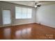 Bright living room with hardwood floors, a ceiling fan, and a door to the porch at 129 Steinbeck Way, Mooresville, NC 28117