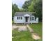 Exterior view of a one-story home with a gravel driveway and black shutters at 134 S Jackson Rd, Lancaster, SC 29720