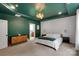 Beautiful bedroom featuring stylish accent wall, neutral carpet, and dark green painted walls and tray ceiling at 1355 Cilantro Ct, Fort Mill, SC 29708