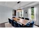 Elegant dining room with a modern chandelier, large windows, and seating for eight at 1355 Cilantro Ct, Fort Mill, SC 29708