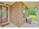 Inviting covered front porch with brick detailing, cozy seating, and a welcoming entrance at 1355 Cilantro Ct, Fort Mill, SC 29708