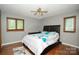 Bedroom with ceiling fan, two windows and a bed with black leather headboard at 1565 Earnhardt Rd, Salisbury, NC 28146