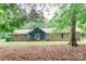 Charming brick home with a blue door, A-frame entry and mature trees in a lush setting at 1565 Earnhardt Rd, Salisbury, NC 28146