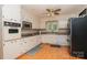 Functional kitchen featuring white cabinets, modern appliances, and hardwood floors at 1565 Earnhardt Rd, Salisbury, NC 28146