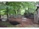 Leafy backyard featuring a dog house, a pet pond, and a wooden fence at 1789 Paris Dr, Conover, NC 28613