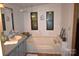 Relaxing bathroom with a large soaking tub, vanity, and dual windows, creating a serene and well-lit retreat at 1789 Paris Dr, Conover, NC 28613