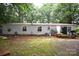 Back exterior of gray home featuring mature trees, with a grill and patio at 1789 Paris Dr, Conover, NC 28613