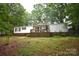 Charming manufactured home with a welcoming porch, surrounded by lush greenery and mature trees at 1789 Paris Dr, Conover, NC 28613