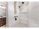 Bathroom with neutral tile shower featuring a shower seat and handheld sprayer at 1818 Winding Mist Dr, Belmont, NC 28012