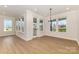 Bright dining area with hardwood floors, neutral walls, a stylish chandelier, and large windows at 1818 Winding Mist Dr, Belmont, NC 28012
