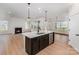 Beautiful open concept kitchen with a white island and stainless steel appliances next to a living room with fireplace at 1818 Winding Mist Dr, Belmont, NC 28012