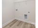 Practical laundry room with wood-look floors, shelving, and utility connections at 1818 Winding Mist Dr, Belmont, NC 28012