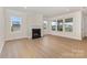 Bright and open living room with hardwood floors, a fireplace, and large windows at 1818 Winding Mist Dr, Belmont, NC 28012