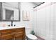 Traditional bathroom with a wood vanity, quartz countertop, framed mirror, and a shower with a white shower curtain at 201 Forest Rd, Taylorsville, NC 28681