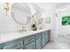 Bright bathroom featuring dual vanity, grey cabinets, quartz countertop, gold faucets, and modern circular mirrors at 201 Forest Rd, Taylorsville, NC 28681