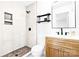 Modern bathroom featuring a tiled shower stall, floating shelves, a wood vanity, white countertop and black hardware at 201 Forest Rd, Taylorsville, NC 28681