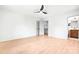This spacious bedroom features a ceiling fan, light wood floors, a closet, and a partial view of an ensuite bathroom at 201 Forest Rd, Taylorsville, NC 28681