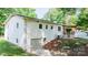 Rear elevation of a white brick house with a walkout basement, green lawn, and treed lot at 201 Forest Rd, Taylorsville, NC 28681