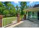 A well-maintained backyard features a concrete patio, white railing, green grass and mature trees at 201 Limerick Dr, Matthews, NC 28104