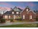 Stunning brick home featuring lush landscaping and a welcoming covered front porch at 201 Limerick Dr, Matthews, NC 28104