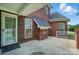 A brick house has a concrete patio with a door, and 2 windows with black awning at 201 Limerick Dr, Matthews, NC 28104