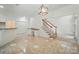 Open-concept living room with staircase, tile flooring, and neutral paint, offering a bright and airy space at 201 Limerick Dr, Matthews, NC 28104