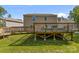 View of the backyard showcasing a large deck, green lawn, and the back of the home at 2021 Tarzi Ln, Charlotte, NC 28215