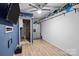 Finished basement area is complete with ceiling fan, shelving, and refrigerator at 2021 Tarzi Ln, Charlotte, NC 28215