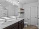 Bathroom with updated modern mirror, double sink vanity, walk-in shower, and decorative shelving at 2021 Tarzi Ln, Charlotte, NC 28215