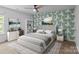 Well-lit bedroom features an accent wall with a palm-leaf pattern and a large window with natural light at 2021 Tarzi Ln, Charlotte, NC 28215