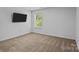 Cozy bedroom featuring plush carpeting, a bright window, and mounted television at 2021 Tarzi Ln, Charlotte, NC 28215
