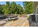 Enjoy outdoor dining on this spacious wooden deck with a table, chairs, and wooded views at 2021 Tarzi Ln, Charlotte, NC 28215