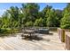 Outdoor living on the deck features a table, chairs, and comfortable seating with a view of the wooded backyard at 2021 Tarzi Ln, Charlotte, NC 28215