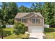 Inviting two-story home with a two-car garage, complemented by lush green landscaping and a well-maintained lawn at 2021 Tarzi Ln, Charlotte, NC 28215