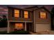 Charming two-story home with brown siding, a two car garage, and a cozy front porch with warm lighting at 2021 Tarzi Ln, Charlotte, NC 28215