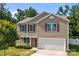 Charming two-story home with a two-car garage, red shutters, and a well-manicured lawn under a clear blue sky at 2021 Tarzi Ln, Charlotte, NC 28215