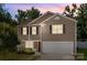 Charming two-story home featuring a two-car garage, complemented by well-maintained landscaping and a beautiful sunset sky at 2021 Tarzi Ln, Charlotte, NC 28215