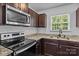 Kitchen featuring stainless steel appliances, dark cabinets, granite countertops, and stainless steel oven at 2021 Tarzi Ln, Charlotte, NC 28215